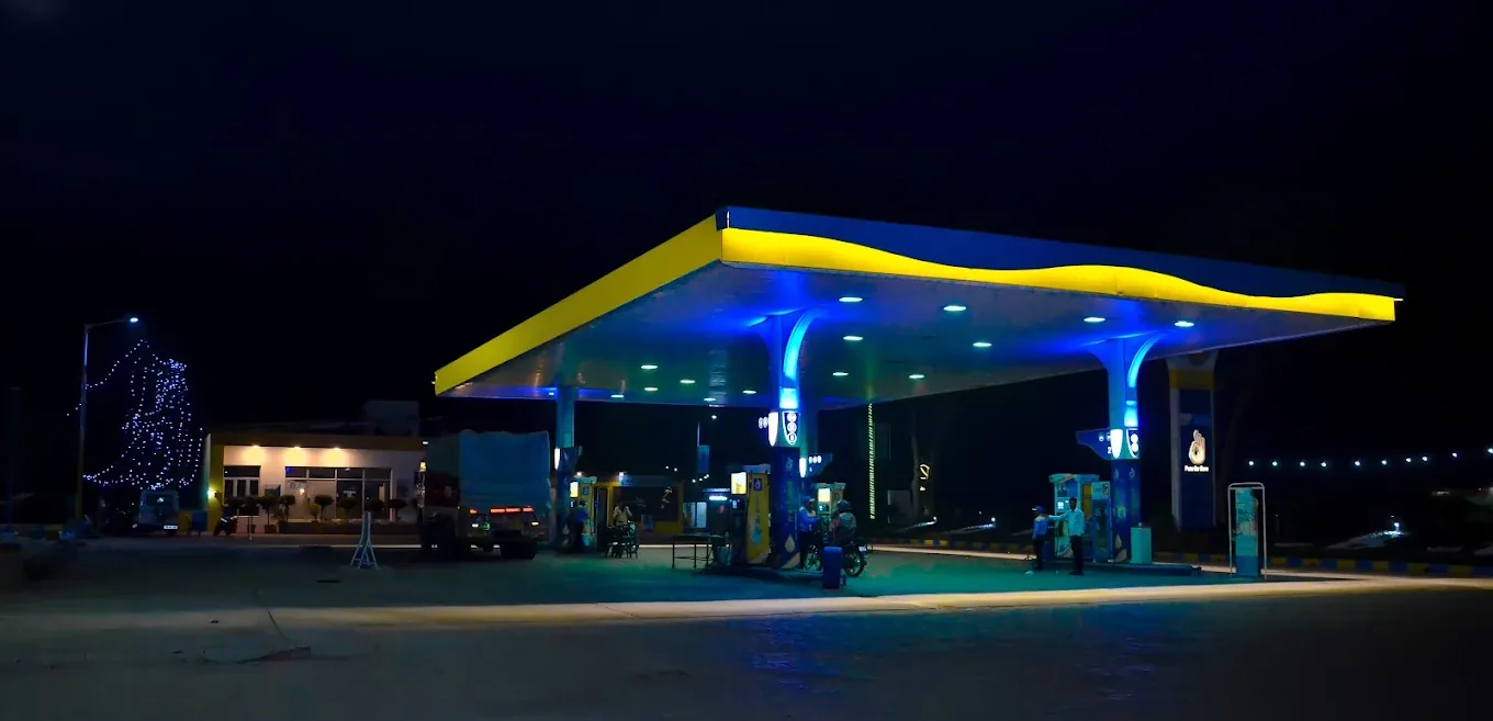 Laraiti Devi Filling Station at night, canopy lit, trucks on the forecourt